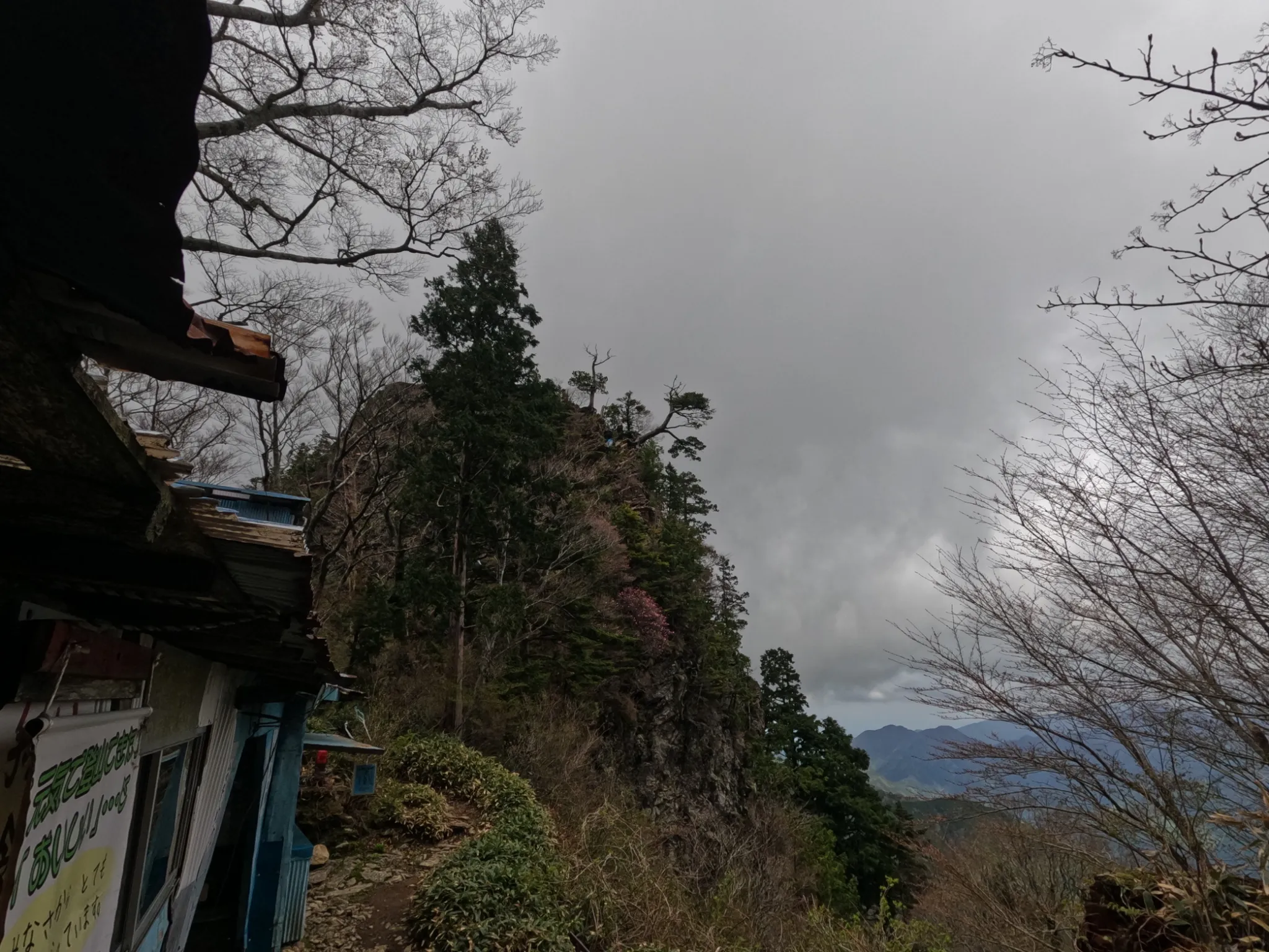 石鎚山中腹の様子。岩場の上に神社の建物と大きな岩が見える。